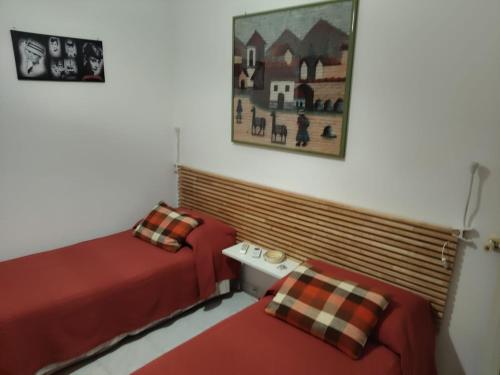 a room with two beds and a picture on the wall at Casa di Elena - Centro Storico in Scicli