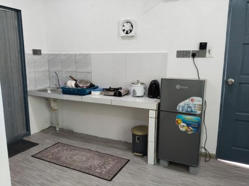 a small kitchen with a counter and a refrigerator at D'semporna Homestay in Semporna