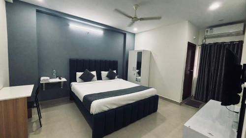 a bedroom with a bed and a desk in a room at Hotel Maski Suties in Kondapur