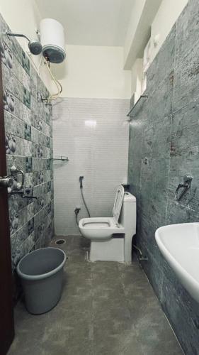 a bathroom with a toilet and a tub and a sink at Hotel Maski Suties in Kondapur