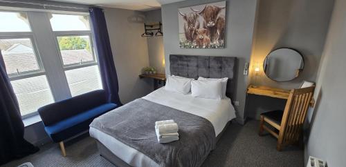 a bedroom with a bed and a mirror and a chair at Cysgu Dda - Sleep Well in Pembroke Dock