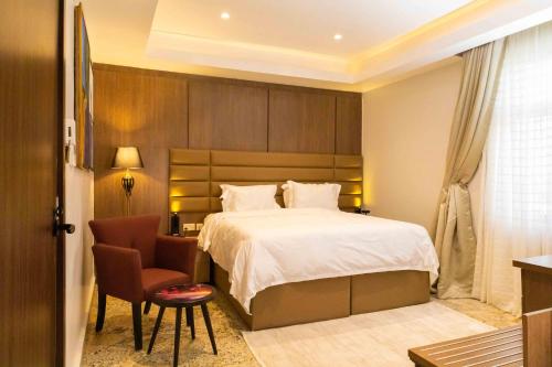a hotel room with a bed and a chair at King Georges Court in Mama