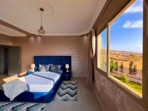 a bedroom with a bed and a large window at Villa sunset Moulay in Essaouira