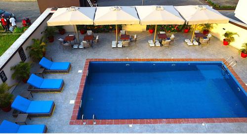 an overhead view of a swimming pool with chairs and umbrellas at King Georges Court in Mama