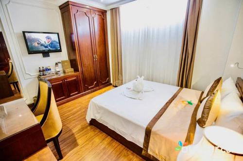 a hotel room with a bed and a table and chairs at ORANGE Hotel & Suites - Danang City CENTER, near Dragon Bridge in Da Nang