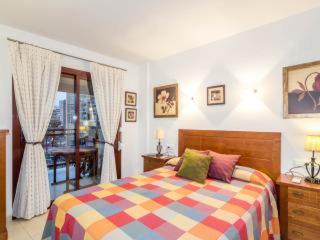 1 dormitorio con 1 cama con una manta colorida en Apartamento Torremar, en Benidorm