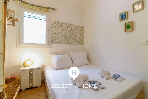 a bedroom with a bed with white sheets and a window at SELECT'soHOME - Maison avec vue mer - Services et Linge compris - AGAVE in Le Lavandou