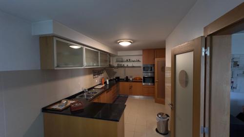 a kitchen with wooden cabinets and a black counter top at Luxury apartment in Espinho