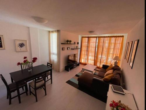 a living room with a couch and a table at Apartamento 2 Dormitorios Las Americas in Playa de las Americas