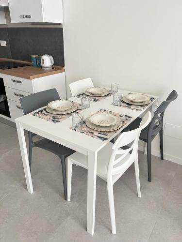 a white table with chairs and plates on it in a kitchen at Casa Vacanze da Marco & Carmela in Perugia