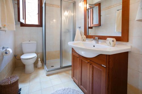 Un baño con ducha, lavabo e inodoro. en Villa Magnolia, en Palaia Epidavros
