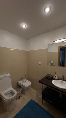 a bathroom with a toilet and a sink and a mirror at Luxury apartment in Espinho