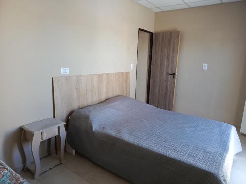 ビージャ・レヒナにあるApart Los Laureles departamento 2のベッドルーム1室(ベッド1台、テーブル、ドア付)