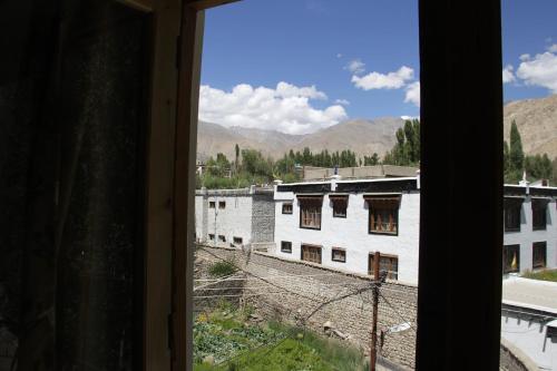 a view from a window of a white building at Mentokling Guest House and Garden Restaurant in Leh