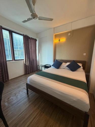 una camera da letto con un letto grande con cuscini blu di Arrival View a Città di Malé