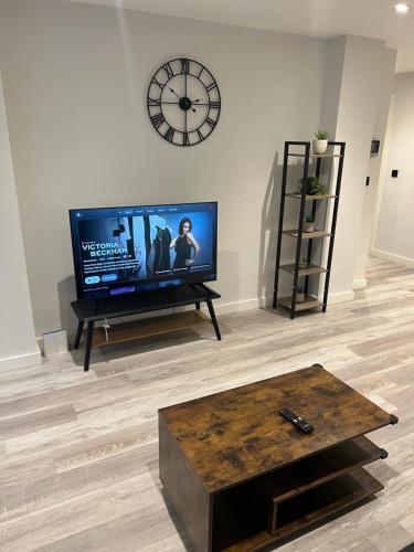 a living room with a flat screen tv and a coffee table at Modern smart Apartments - Digbeth Central Birmingham in Birmingham