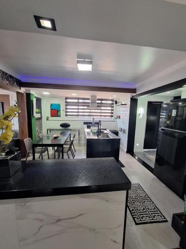 a kitchen and living room with a table and a kitchen and a dining room at Frente Mar Santos 130 m2 in Santos