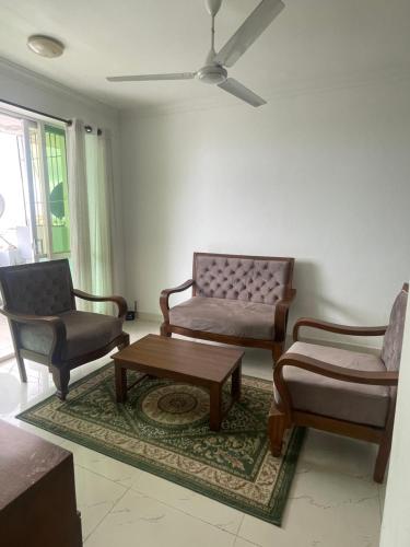 a living room with two chairs and a coffee table at Time and Spenser Apartment ,condo in Wellawatta
