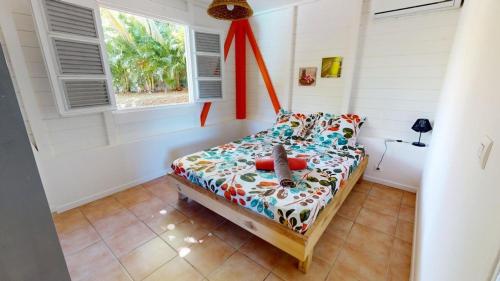 a small bedroom with a bed and a window at LocationTiBalisier pointe sud Martinique in Sainte-Anne