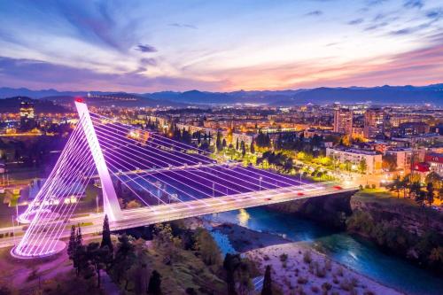 a lit up bridge over a river at night at Forte Mare Apartment in Podgorica