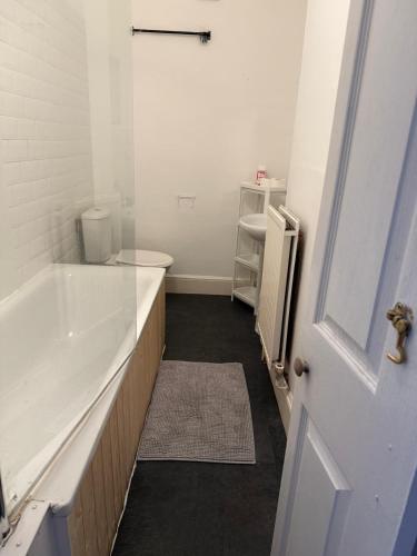 a bathroom with a tub and a toilet and a sink at 5 Brunswick - room 04 in Bristol