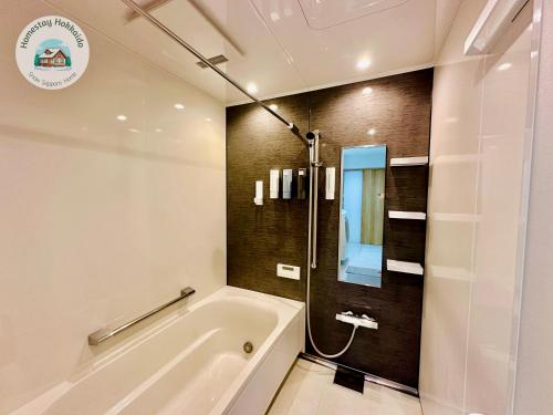 a bathroom with a bath tub and a shower at Snow Sapporo Homestay in Sapporo