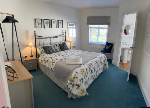 - une chambre avec un lit et un bureau avec deux lampes dans l'établissement Beer Bakery Cottages - Charming Cottage Retreat - 2 mins from Beach with Car Parking space, à Beer