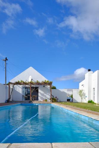 a swimming pool with a gazebo next to a house at MM Good Times in Gansbaai