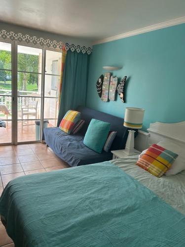 ein Wohnzimmer mit einem Bett und einer Couch in der Unterkunft la Désirade in Sainte-Luce