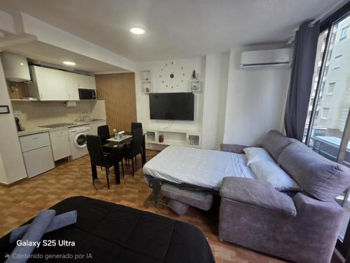 ein Wohnzimmer mit Couch und Tisch und eine Küche in der Unterkunft Aventura Playa y Sol Santa Pola in Santa Pola