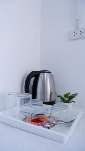 a tray with glasses and a tea kettle on a table at Baanlek Guest House in Ko Lanta