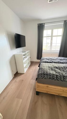a bedroom with a bed and a flat screen tv at Schöne Ferienwohnung in Grünhain-Beierfeld