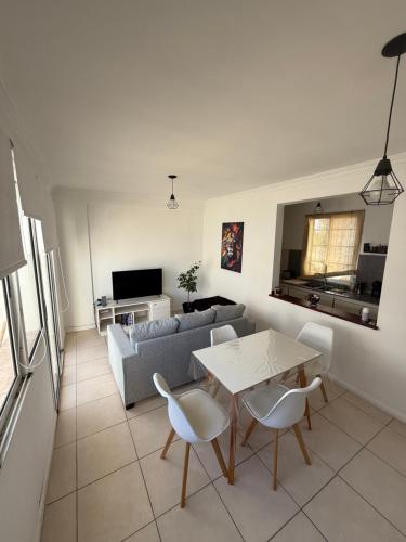 ein Wohnzimmer mit Sofa und Tisch in der Unterkunft Departamento Irigoyen in Santa Rosa