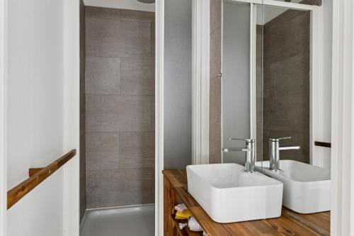 a bathroom with a white sink and a tub at Luxury Paris Apt, Metro 4 & RER B, 6 guests, CDG Access in Paris