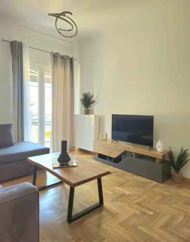 a living room with a couch and a tv at Mary's luxury apartment Nemea 2 in Neméa