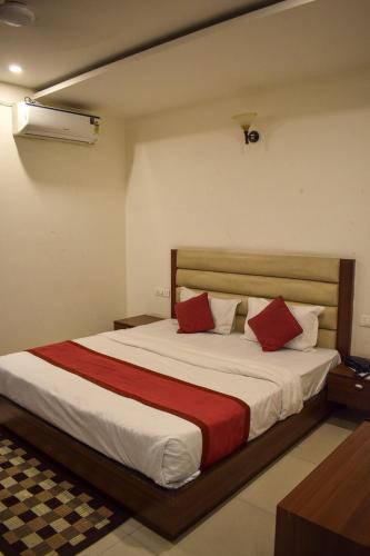 a bedroom with a large bed with red pillows at Pam Green in Mussoorie