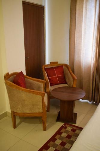 a living room with two chairs and a table at Pam Green in Mussoorie
