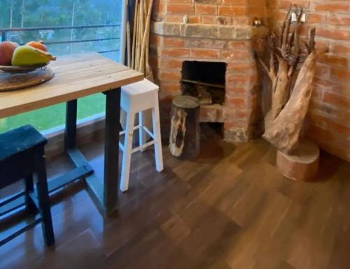 Habitación con mesa y chimenea de ladrillo. en Hospedaje Elinna, en Pichilemu