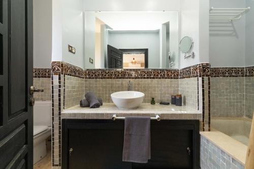 un baño con lavabo y espejo en Riad azzouina, en Marrakech