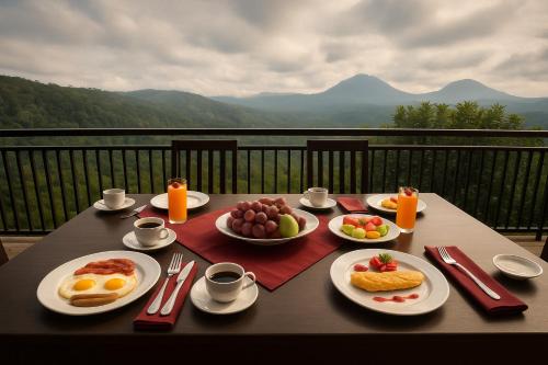 a table with plates of breakfast food on a balcony at Shitala Villa in Munduk