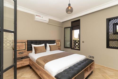 Un dormitorio con una cama grande y una ventana. en Riad azzouina, en Marrakech