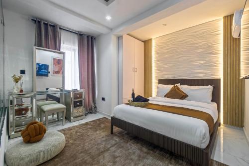 a hotel room with a large bed and a desk at The Champagne Suite in Mama