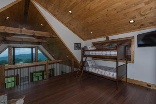 a loft bedroom with a bunk bed in a house at Peregrine's Perch at Eagles Nest in Elk Park