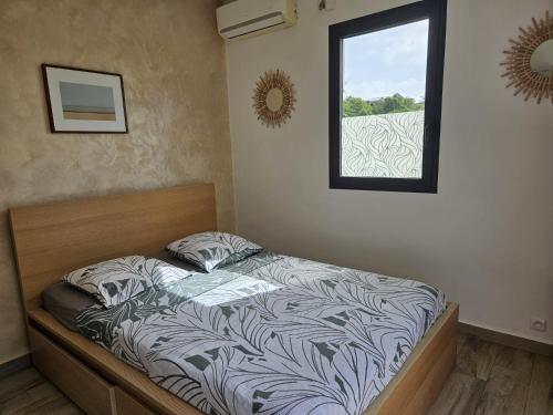 a bed in a room with a window at Studio Belle Place in Le Gosier