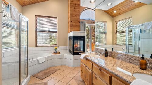 a bathroom with a tub and a fire place at Linaker Lodge by AvantStay Gorgeous Cabin in Big Bear w Views in Big Bear Lake