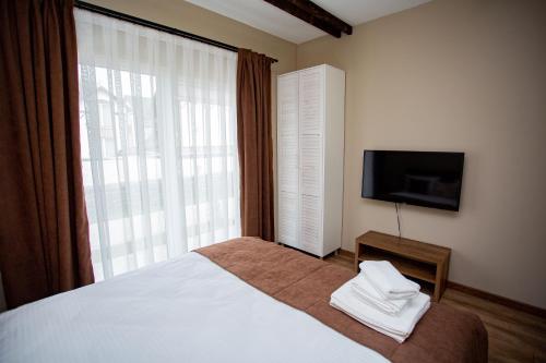 a bedroom with a large bed and a television at My Home Apartments in Berehove