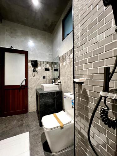 a bathroom with a white toilet and a sink at Eyeful Ella in Ella