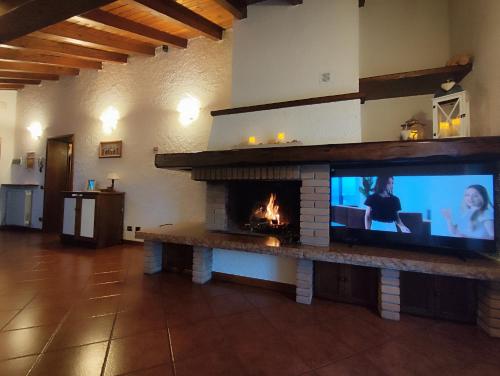 a fireplace in a living room with a tv and a fire place at Il Nido Di Montagna in Pian degli Ontani