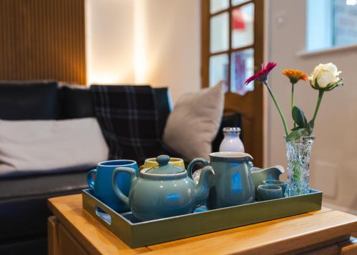 a tray with blue cups and vases on a table at Aethelred Annexe - New Build with Full Amenities in Winchester