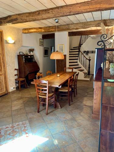 een eetkamer met een houten tafel en stoelen bij La Maison Provençale in La Roquebrussanne